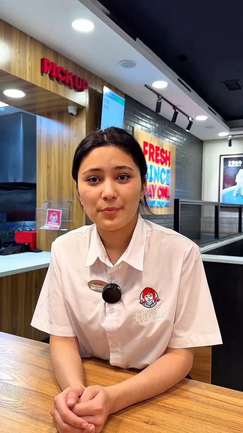 Wendy’s xodimi restoran zalida stol yonida